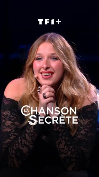 This ad is for the TV show La Chanson Secrète, which airs on the TF1+ channel. The ad shows a woman wearing a black dres